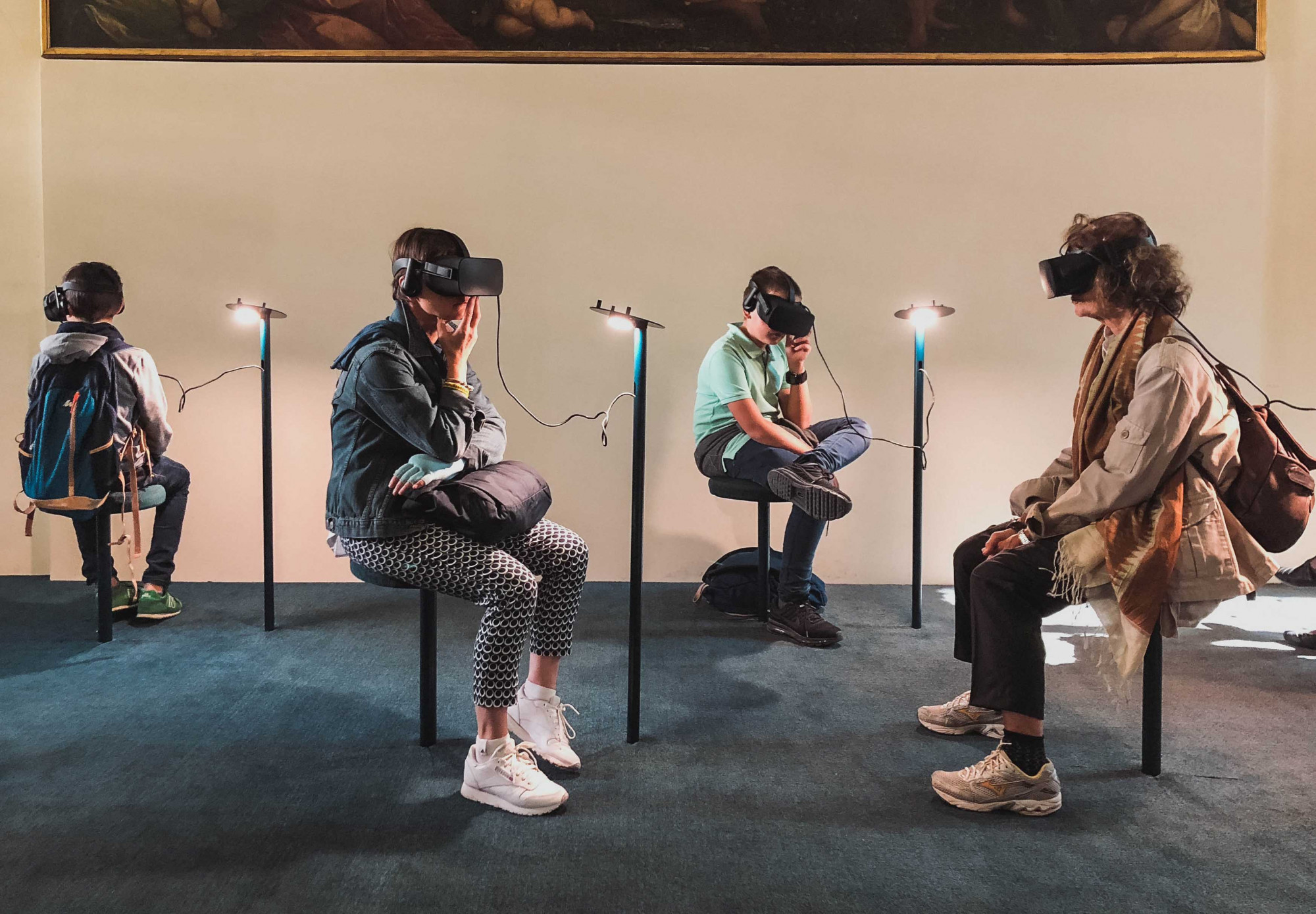 Two adults and two children sit in a museum with VR sets on for a digital experience