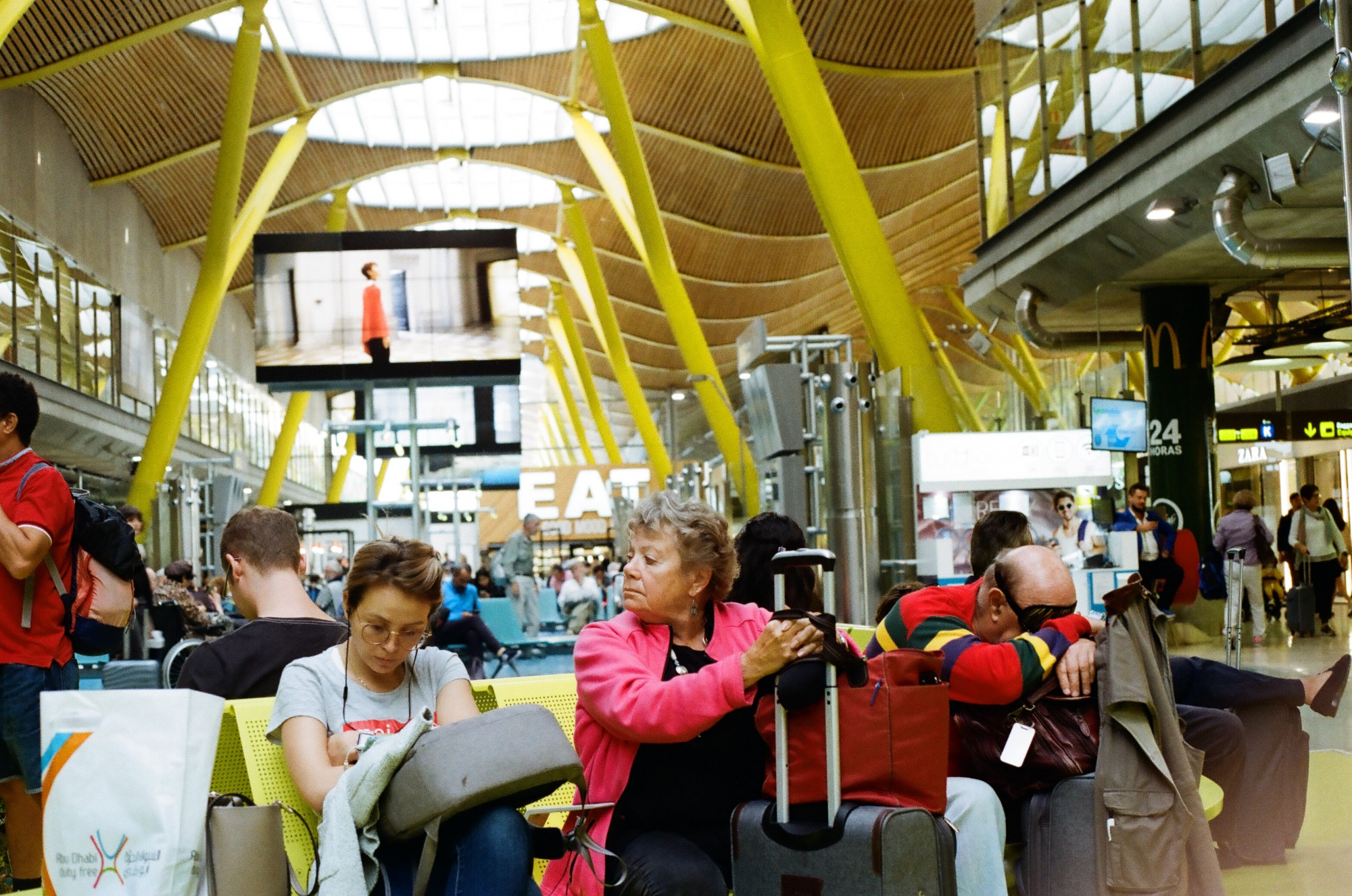 Miserable and tired looking passengers sit disconsolate in Madrid airport by Carlos Coronado on Unsplash