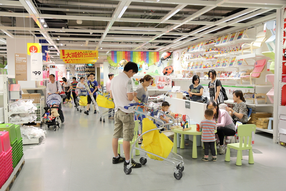 A family in a homeware and furniture store. The children are playing and the family are using the space for entertainment as well as shopping.