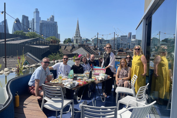 Members of the Mima team celebrate the newly-acquired B Corp status on a sunny rooftop, set against the background of the London skyline