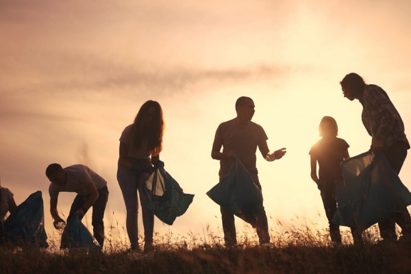 Silhouette volunteers collect plastic: a group team people collect plastic bottles together.